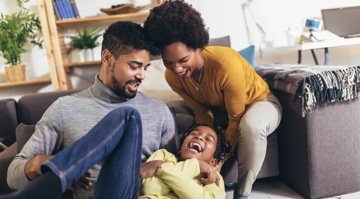 famille qui rigole dans le salon