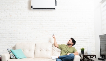 Une homme règle son climatiseur