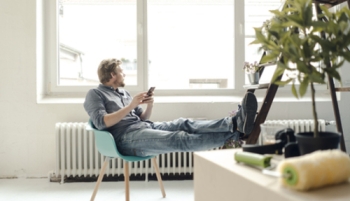 homme dans son salon regarde par la fenêtre