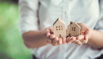 Femme tient des maisons en bois