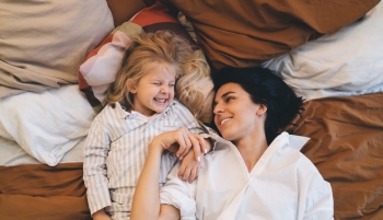 Une femme et sa fille allongées sur leur lit