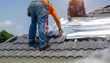 Des artisans installent un isolant en toiture