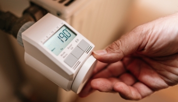 Une personne règle la température sur un thermostat