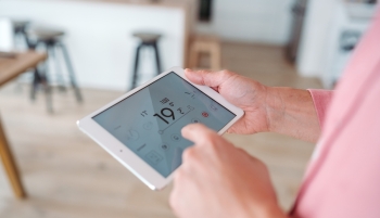 Un homme règle la température sur un thermostat
