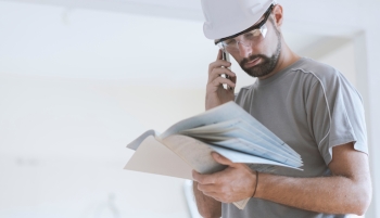 artisan au téléphone avec contrat en main