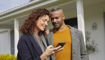 couple devant la maison sur le téléphone