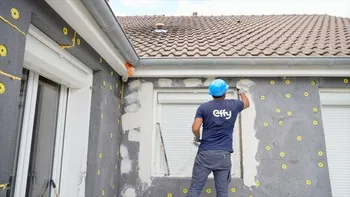 Artisan pose de l'enduit pour 'isolation des murs par l'extérieur