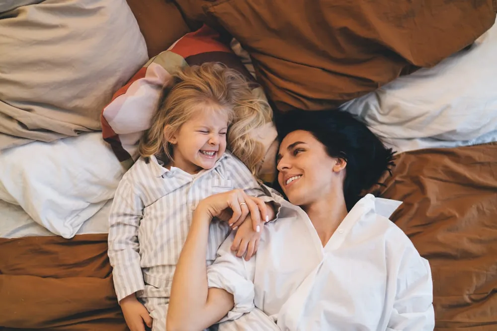 Une femme et sa fille allongées sur leur lit