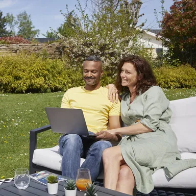 couple dans leur jardin devant un ordinateur